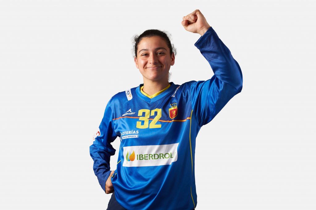 Jugadora de la selección española de hockey levanta el puño celebrando con la camiseta azul oficial de portera de manga larga de las redsticks