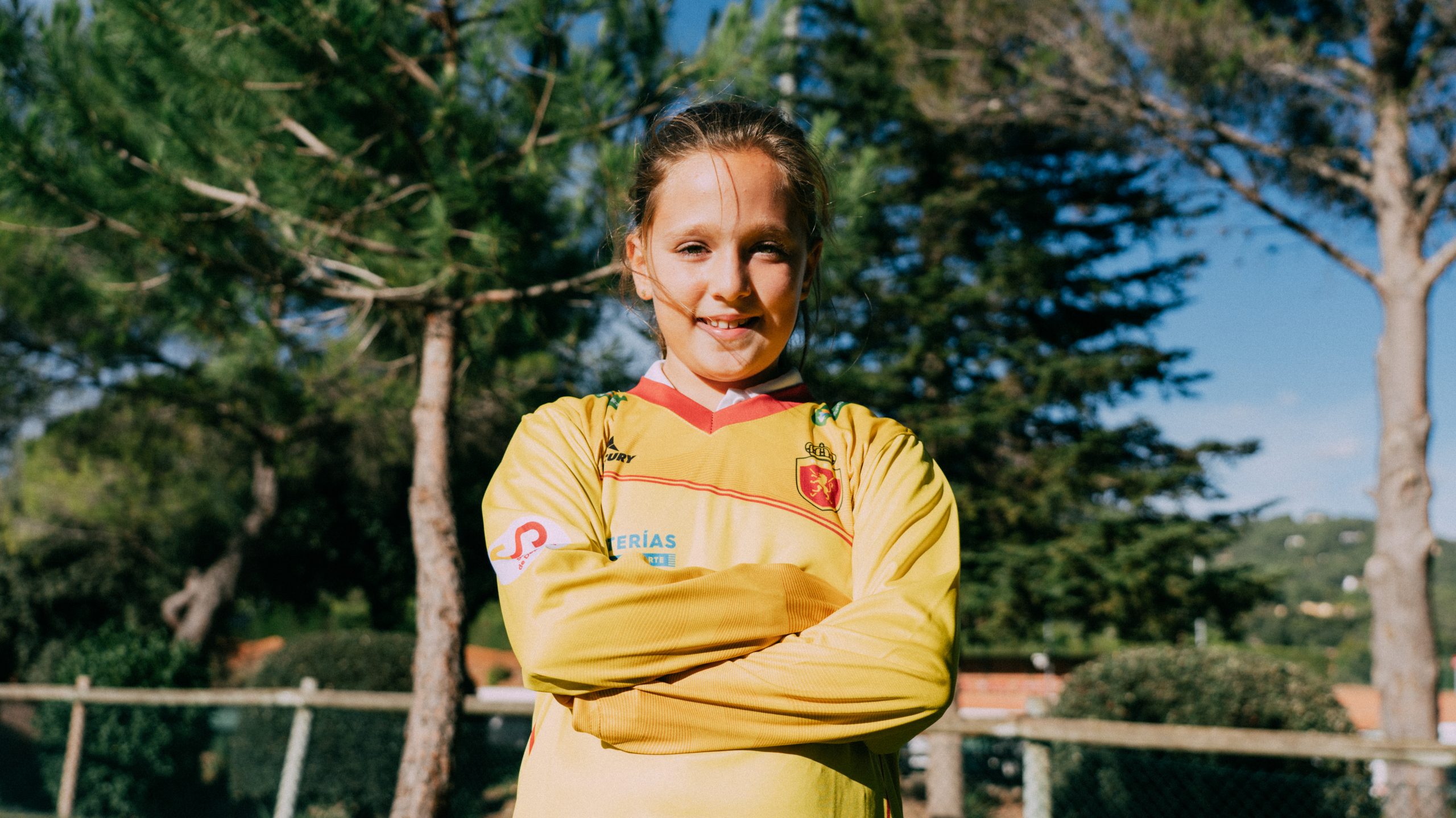 niña de brazos cruzados con la camiseta oficial de portera de la selección española femenina de hockey hierba