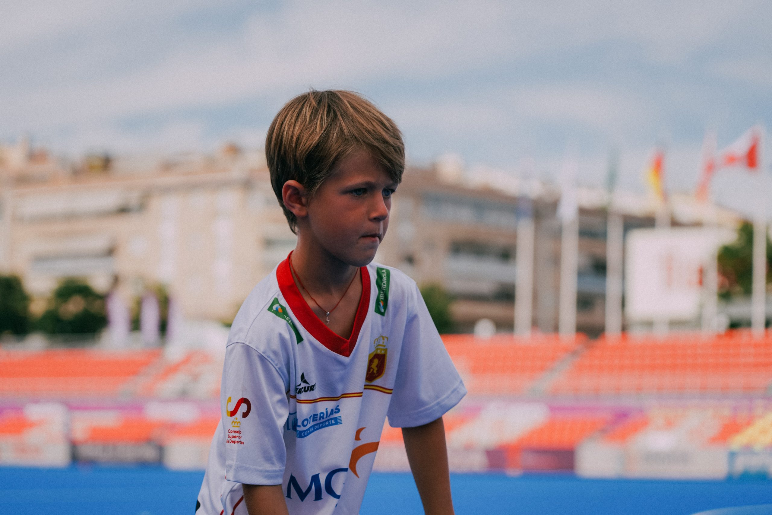 niño jugando a hockey hierba en el estadio de terrassa con la camiseta blanca del equipo nacional