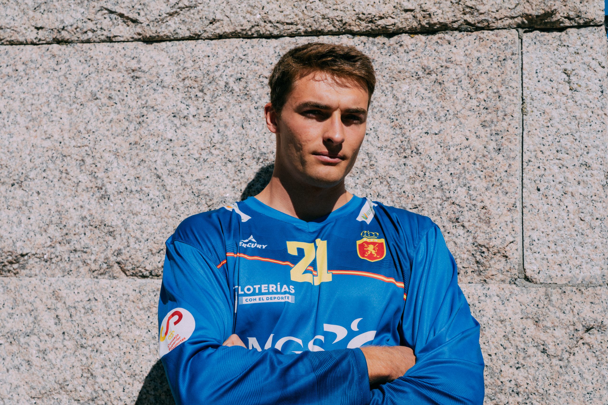 Portero de los Redsticks posa de brazos cruzados con la camiseta mercury azul de manga larga de la selección española de hockey hierba